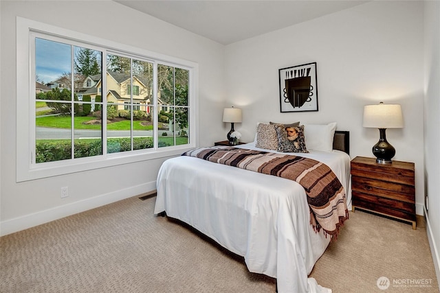 bedroom featuring visible vents, baseboards, and light colored carpet