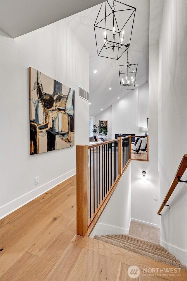 stairway featuring baseboards, visible vents, wood finished floors, and recessed lighting