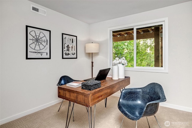 carpeted office featuring visible vents and baseboards