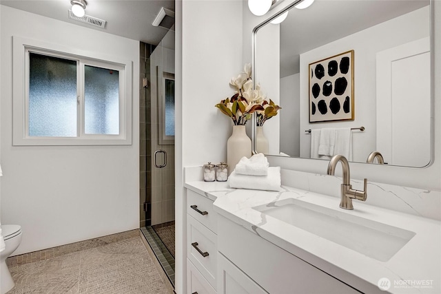 full bathroom featuring toilet, a stall shower, and vanity