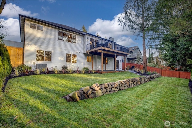 rear view of house with a yard and fence