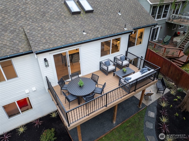 back of house with a deck, roof with shingles, and outdoor lounge area