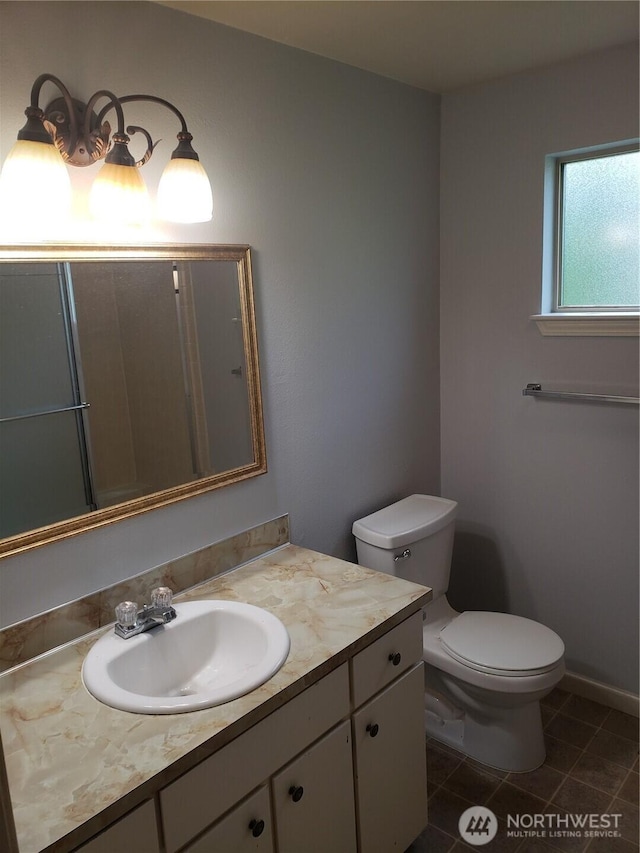 bathroom with tile patterned flooring, vanity, toilet, and baseboards