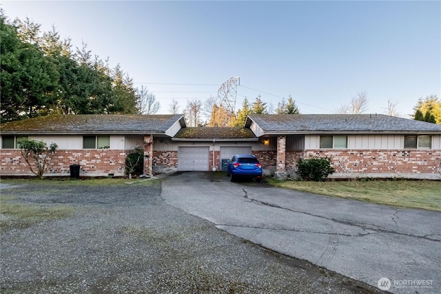 ranch-style home featuring brick siding, driveway, and an attached garage