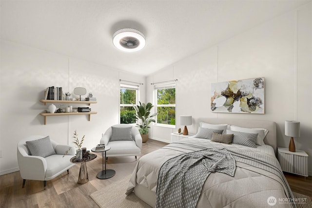 bedroom with vaulted ceiling, radiator heating unit, baseboards, and wood finished floors