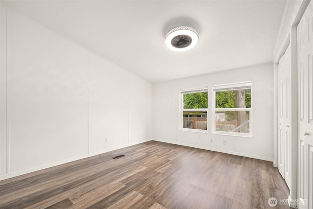 empty room with visible vents and dark wood-style flooring