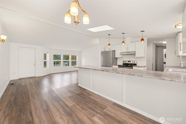 kitchen featuring a sink, stacked washer and clothes dryer, under cabinet range hood, appliances with stainless steel finishes, and lofted ceiling with skylight