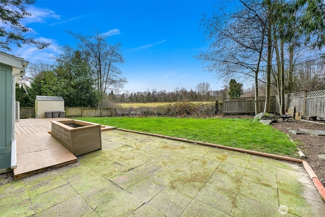 view of patio / terrace with a fenced backyard, an outdoor structure, and a shed