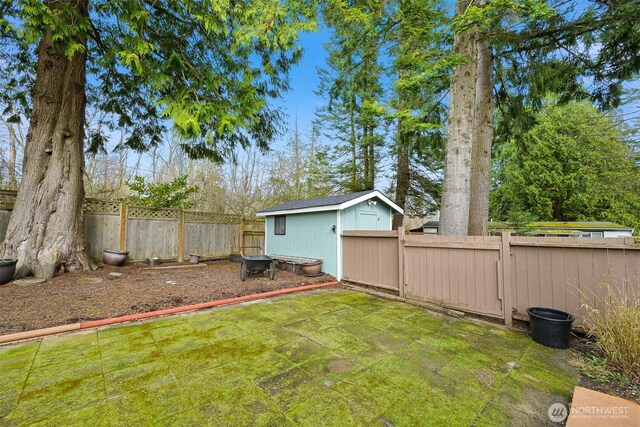 view of yard featuring an outbuilding, a storage unit, and a fenced backyard