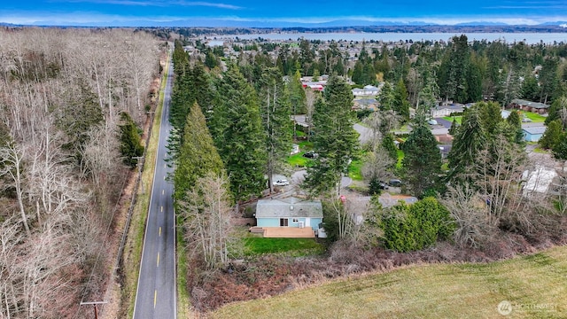 birds eye view of property featuring a wooded view and a water view