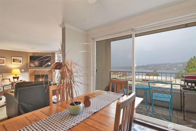 dining space with ornamental molding and a fireplace