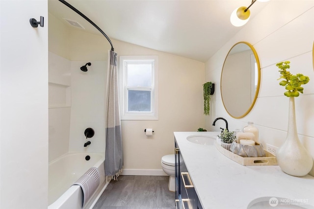 full bathroom featuring wood finished floors, double vanity, a sink, vaulted ceiling, and toilet