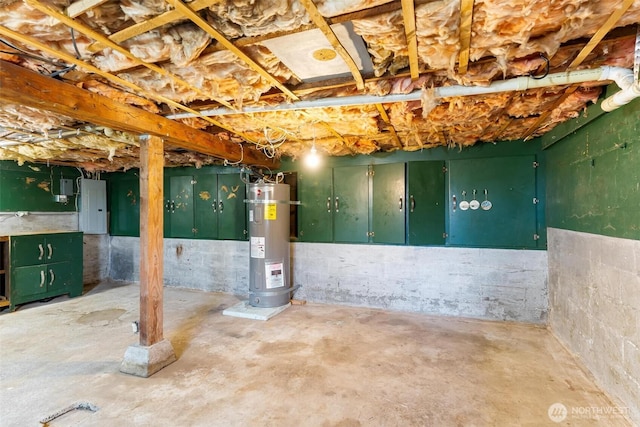 unfinished basement featuring electric panel and electric water heater