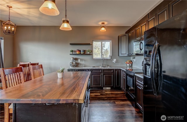 kitchen with dark wood-type flooring, a sink, wood counters, dark brown cabinets, and black appliances