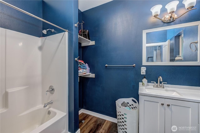 full bathroom with wood finished floors, vanity, baseboards, and shower / bathtub combination