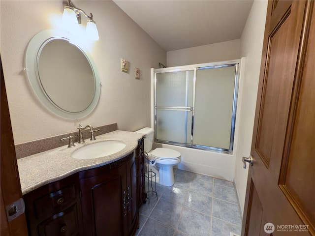 full bath with toilet, shower / bath combination with glass door, tile patterned flooring, and vanity