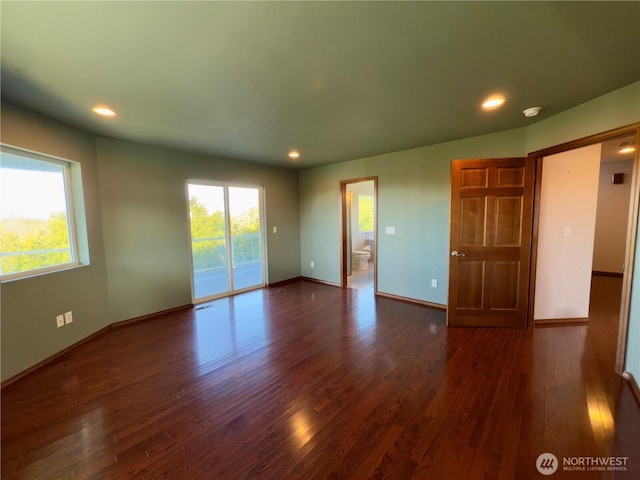 unfurnished bedroom featuring access to outside, multiple windows, wood finished floors, and baseboards