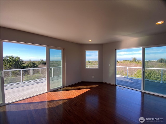 unfurnished room with baseboards, wood finished floors, visible vents, and recessed lighting