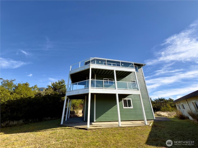 rear view of house with a yard, a patio area, and a balcony