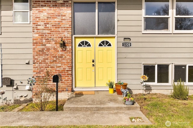 view of exterior entry featuring brick siding