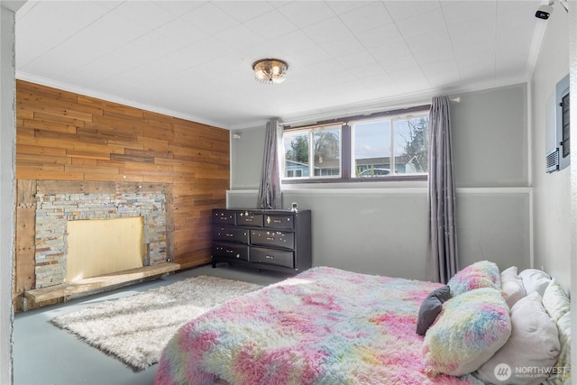 bedroom featuring ornamental molding, wood walls, and a fireplace