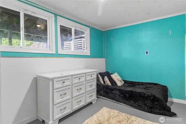 bedroom with finished concrete floors, multiple windows, and baseboards