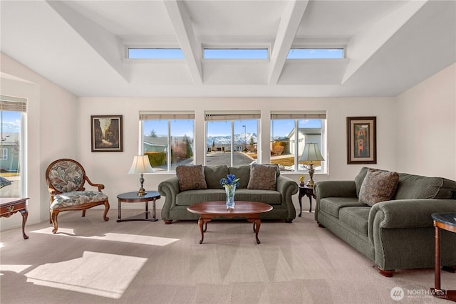 living area with beamed ceiling and light colored carpet