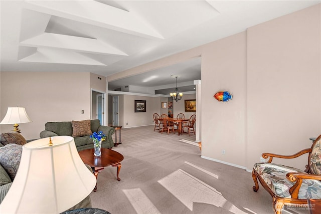 carpeted living area with baseboards and an inviting chandelier