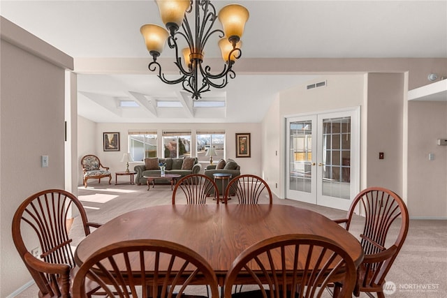 dining room featuring french doors, a notable chandelier, light colored carpet, visible vents, and baseboards