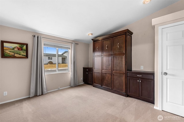 unfurnished bedroom featuring light carpet and baseboards