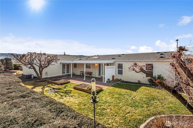 rear view of property with a patio, central AC, a garden, french doors, and a lawn