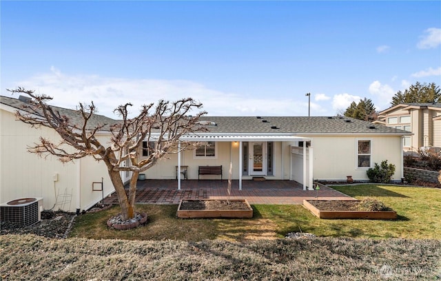 rear view of house with a vegetable garden, central AC, and a patio