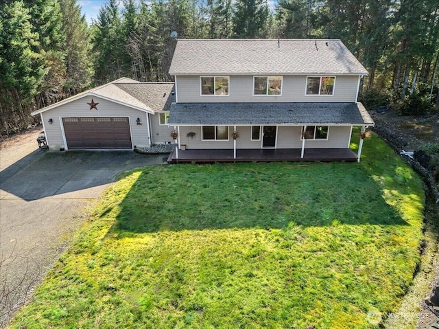 traditional-style home featuring aphalt driveway, a front lawn, a shingled roof, and a garage