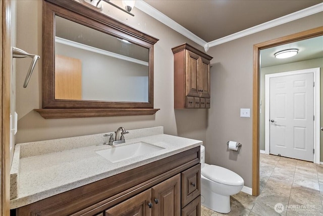 bathroom with toilet, baseboards, crown molding, and vanity