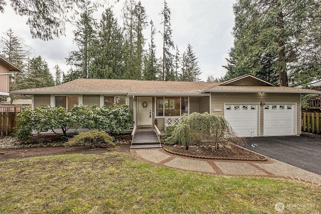 ranch-style house with an attached garage, fence, and driveway