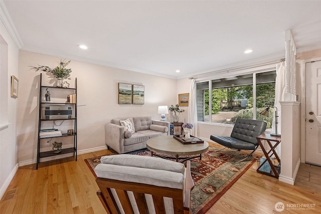 living room featuring light wood finished floors, baseboards, and ornamental molding