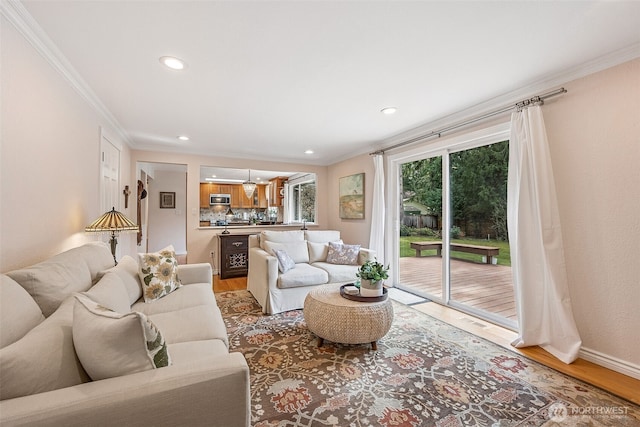 living area with crown molding, recessed lighting, light wood-style floors, and baseboards