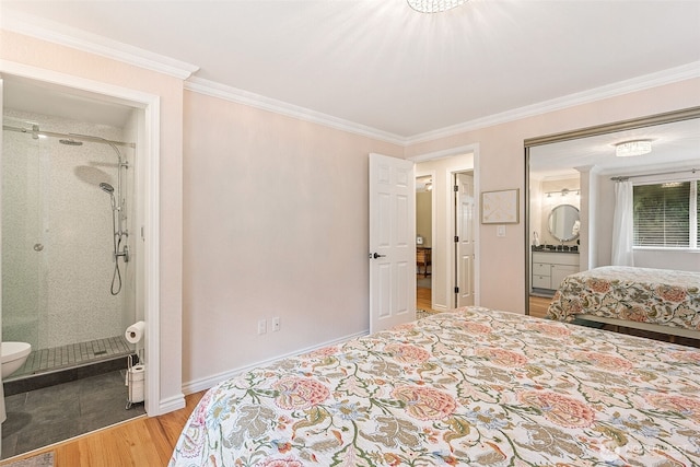 bedroom with crown molding, baseboards, ensuite bathroom, and light wood-style floors