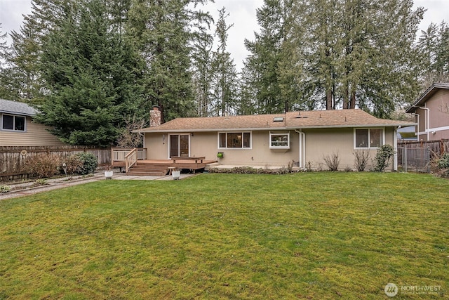 back of house featuring stucco siding, a wooden deck, a fenced backyard, and a yard