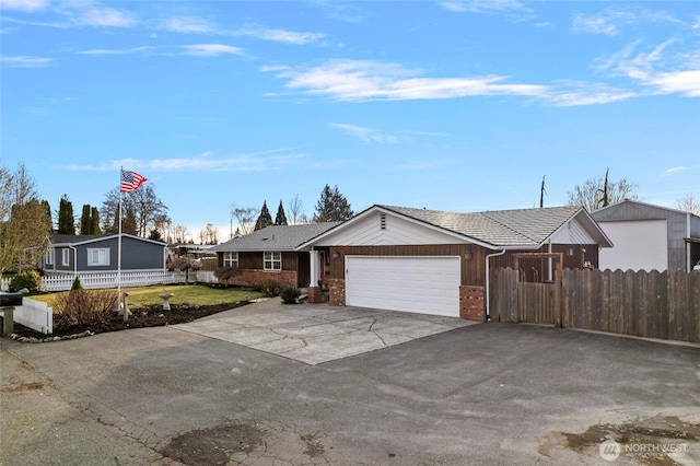 ranch-style house with an attached garage, fence, aphalt driveway, and brick siding