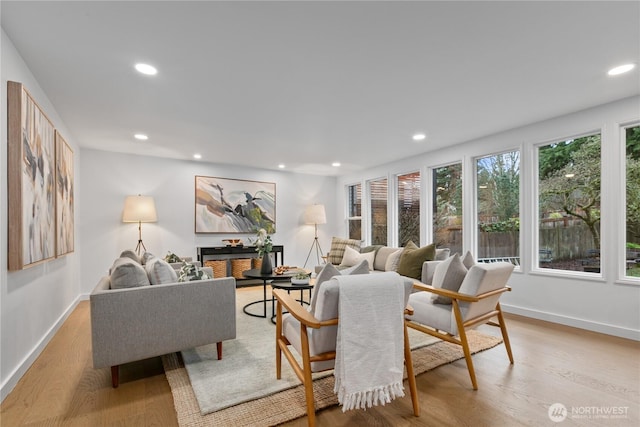 living room with light wood-style floors, recessed lighting, and baseboards