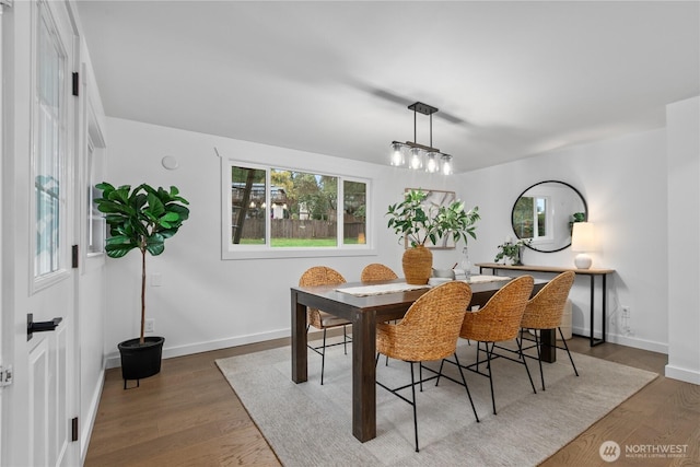 dining space with a wealth of natural light, baseboards, and wood finished floors