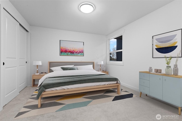 bedroom featuring light carpet, baseboards, and a closet