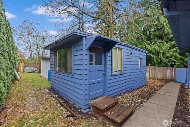 view of outdoor structure featuring an outbuilding and fence