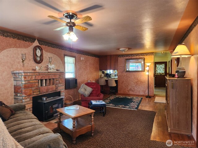 160 Gharet Rd, Randle, WA 98377 - living area featuring wood finished floors, a wood stove, a ceiling fan, and wallpapered walls