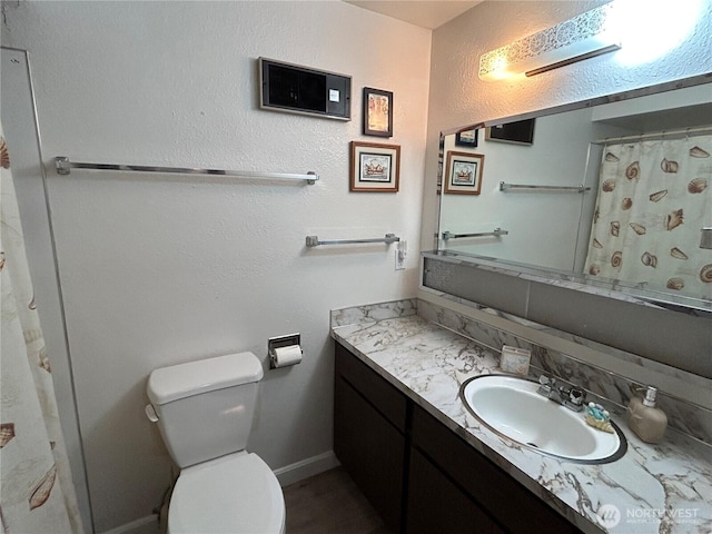 full bathroom with baseboards, a textured wall, toilet, a shower with shower curtain, and vanity