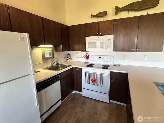 kitchen featuring white appliances, dark wood-style flooring, light countertops, dark brown cabinets, and a sink