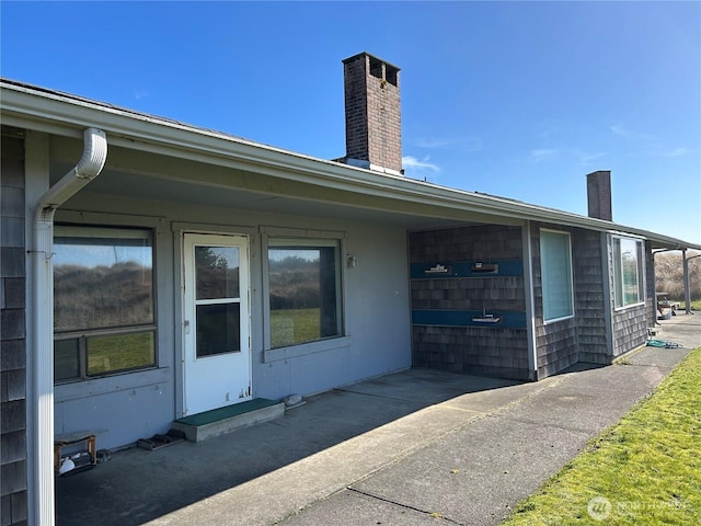 view of exterior entry featuring a chimney