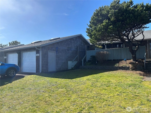 view of home's exterior with an attached garage, fence, and a yard