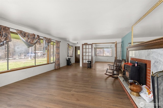 living area with a wood stove, a healthy amount of sunlight, and wood finished floors